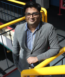 Devinder Kumar leaning on a railing in the Davis Centre