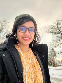 Dilruba Sharmin in selfie wearing yellow sweater and black jacket in snowy background