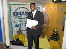 Rahim at his graduation in front of the OUA trophy