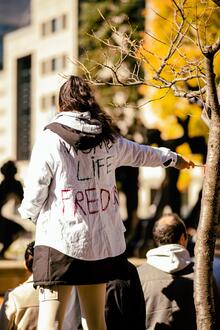 Iranian woman wearing &quot;Woman Life Freedom&quot; jacket in protest 