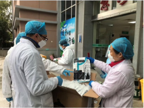 Health care professionals in Wuhan open boxes of protective suits