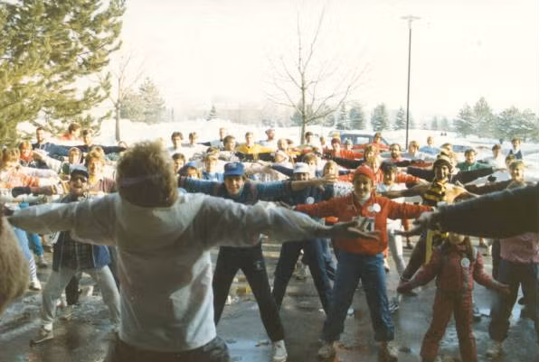 Participants warm up, standing with their feet wide and arms out