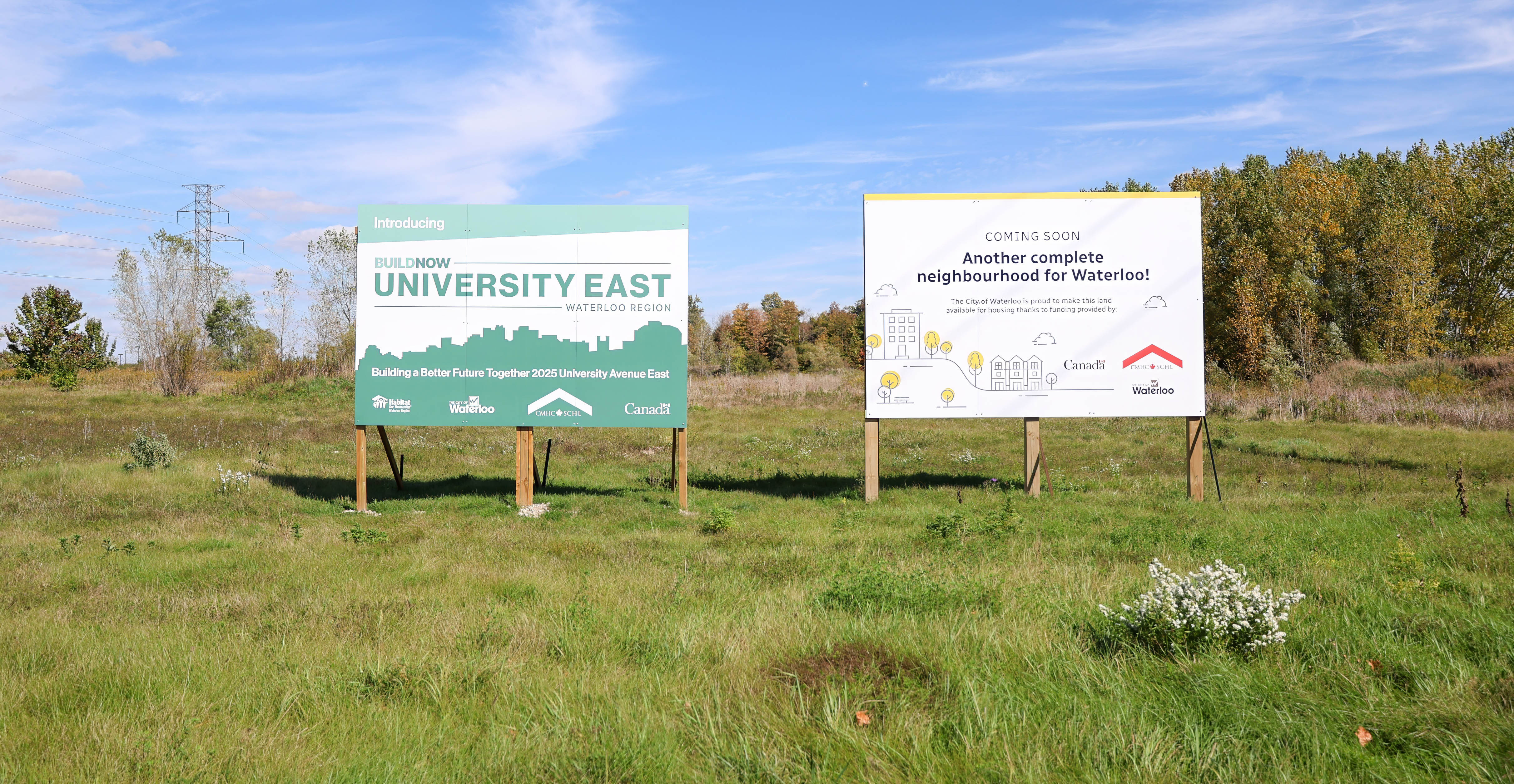 Two large signs in a field promoting the BuildNow initiative