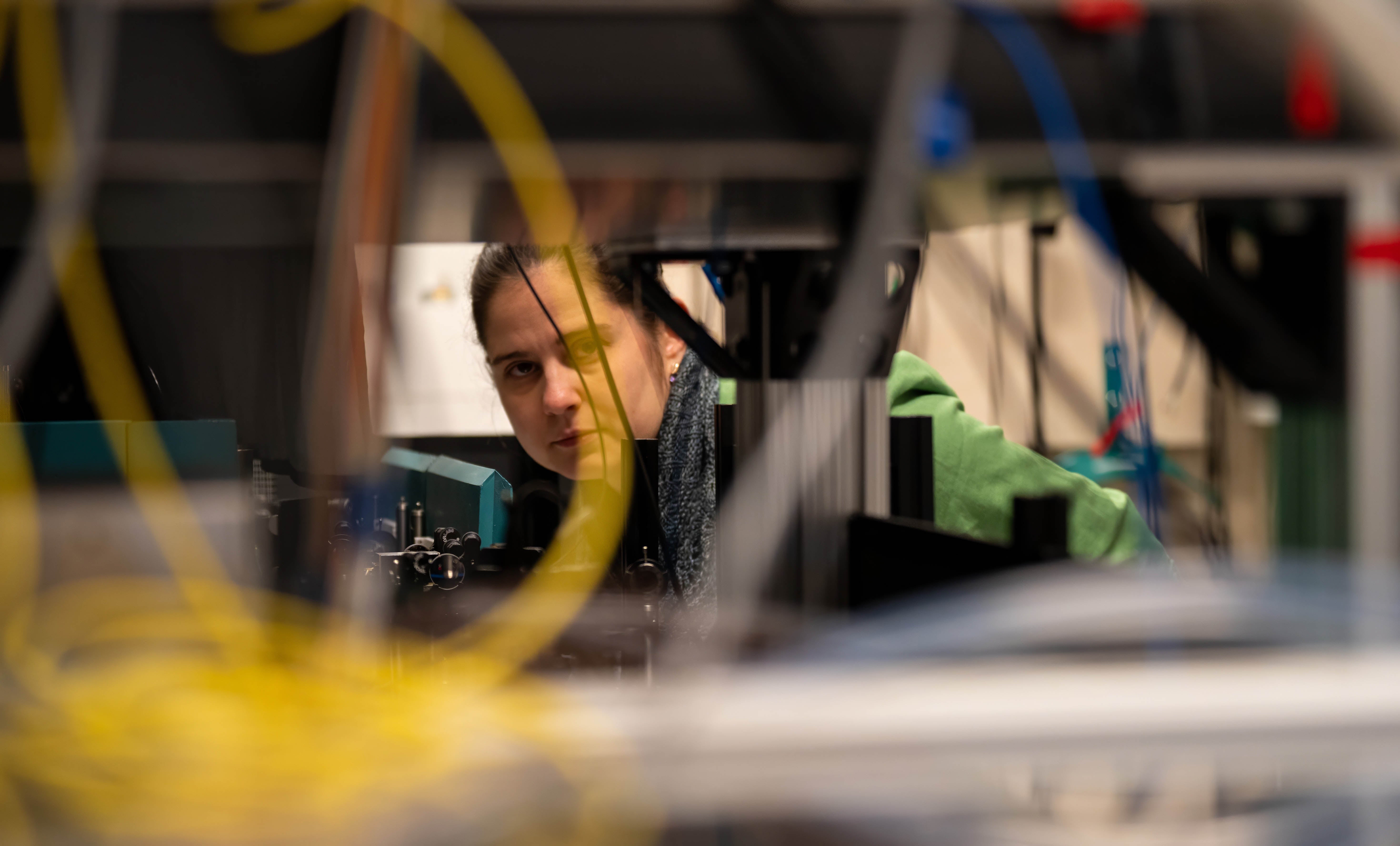 Crystal Senko looks through some wiring near experimental set up