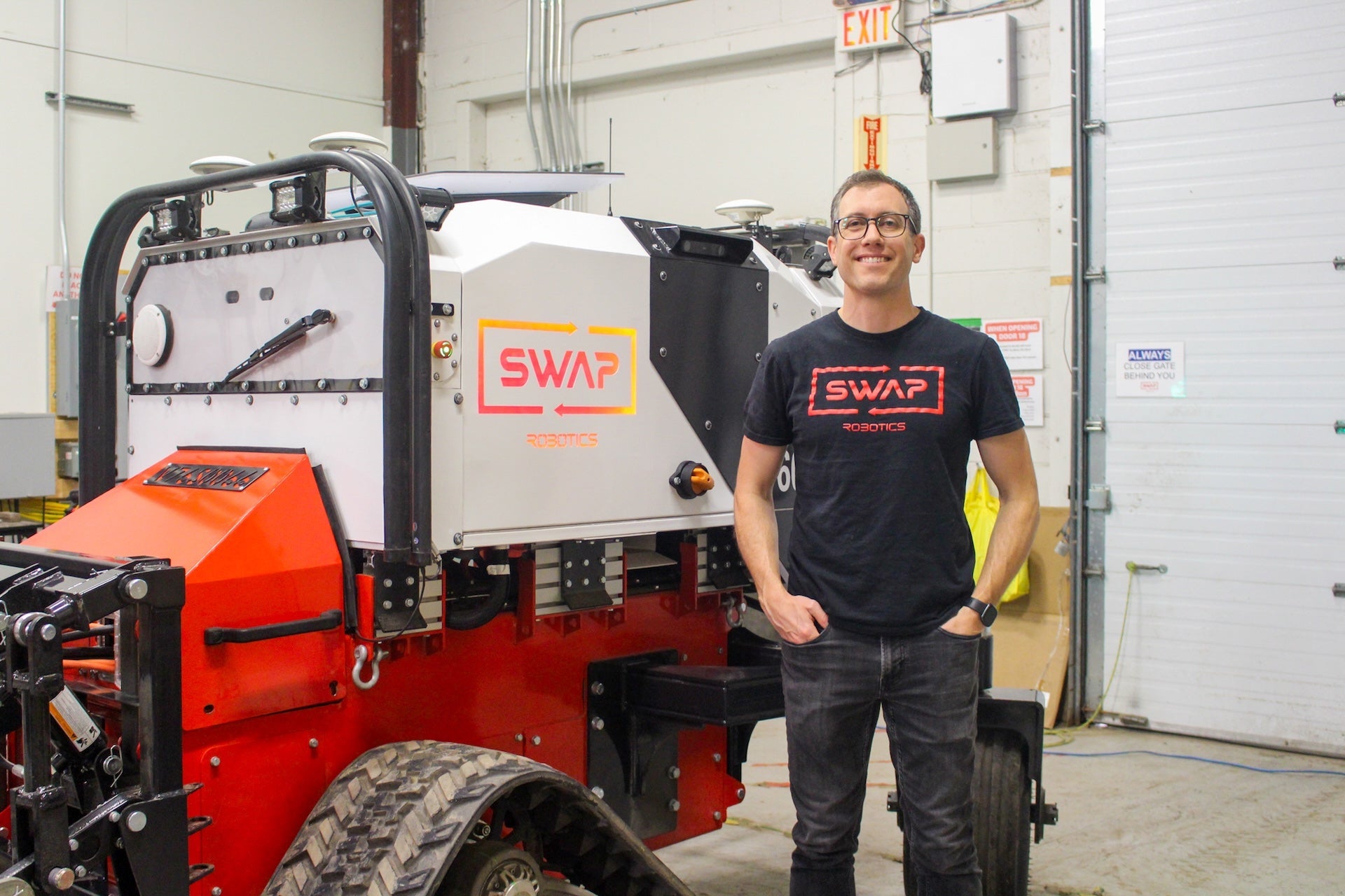 Tim Lichti standing beside Swap Robotics machine
