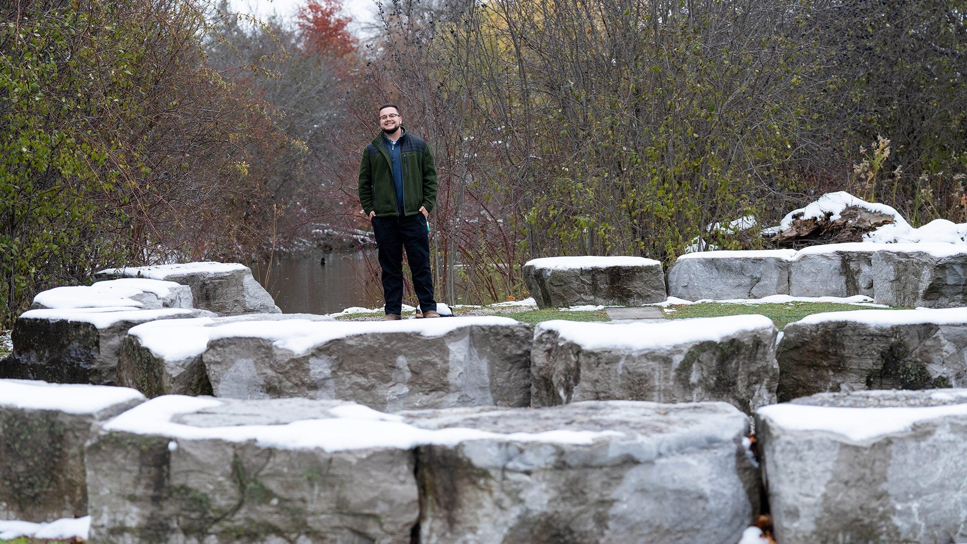 Kian Drew poses near a fire circle on the campus of the University of Waterloo