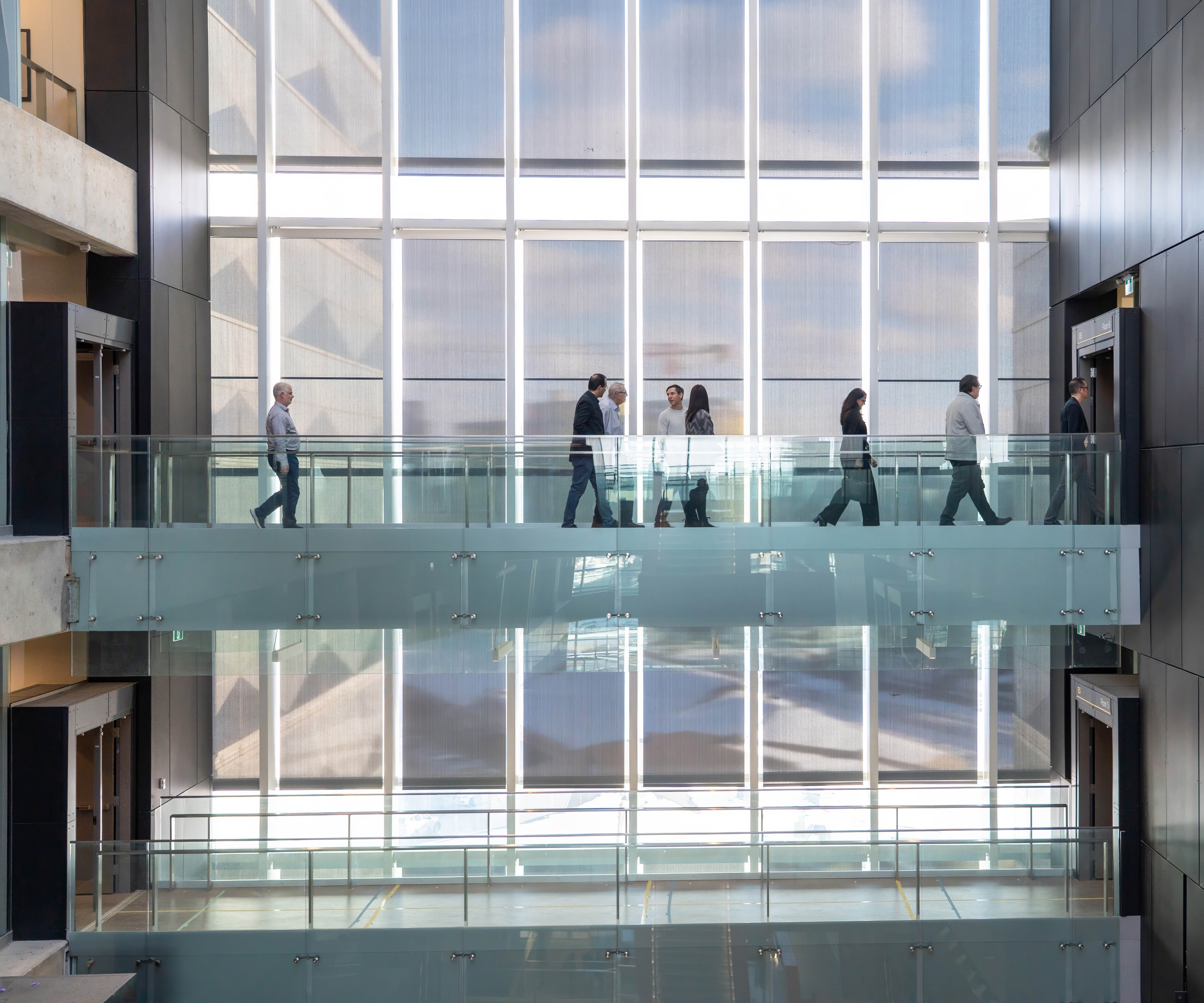 OceanMD delegation cross the fifth level walkway within the Pearl Sullivan Building