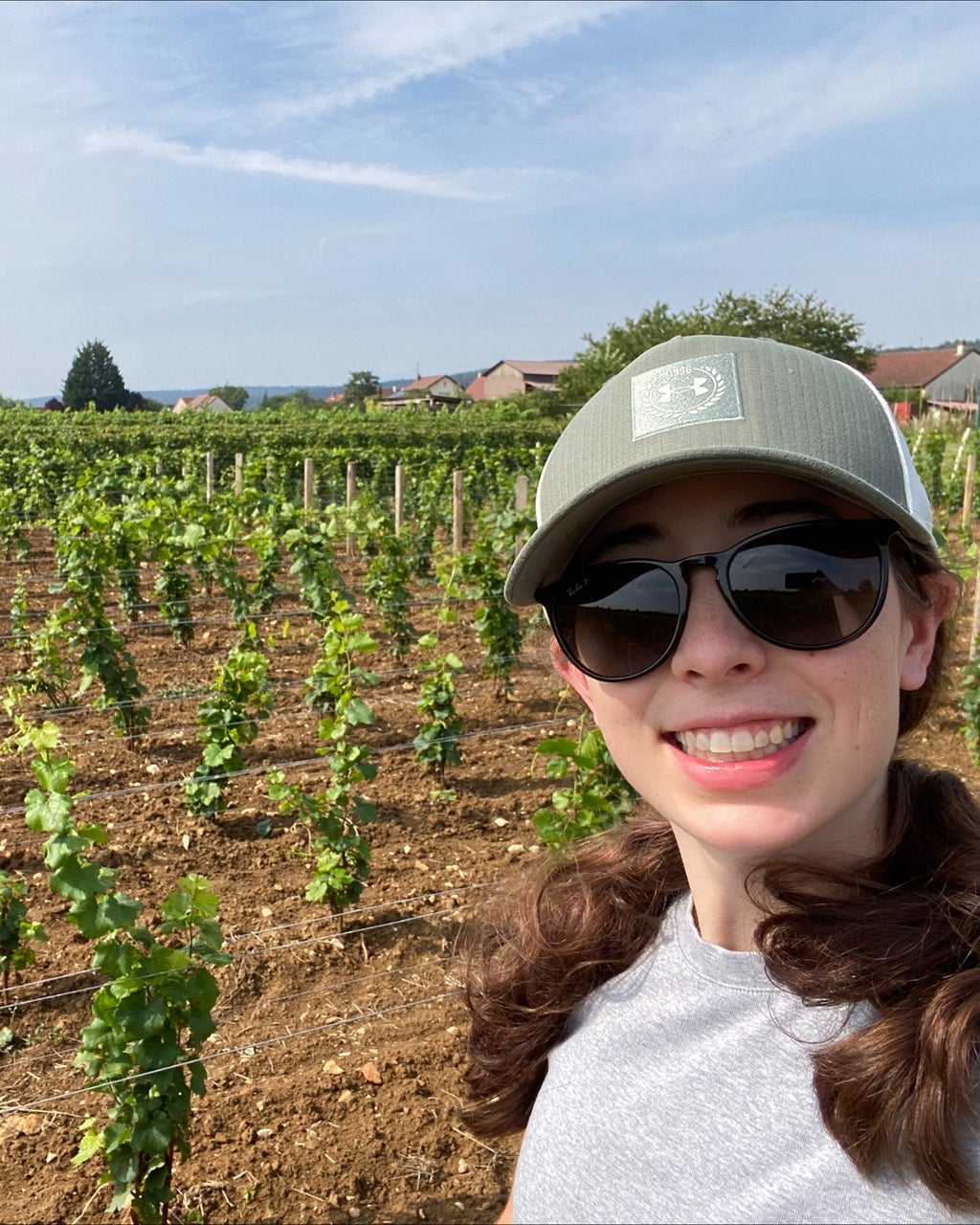 Charlotte smiling with the vineyard in the background