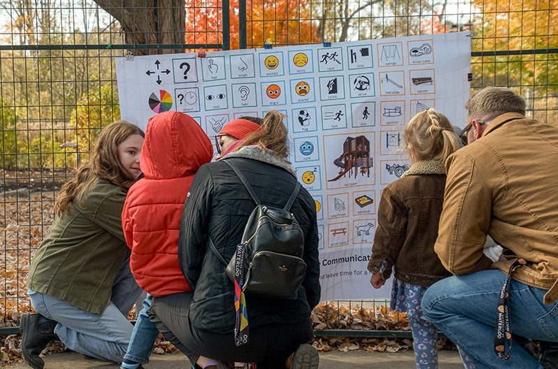 A member of the team works with parents and two young children testing the board