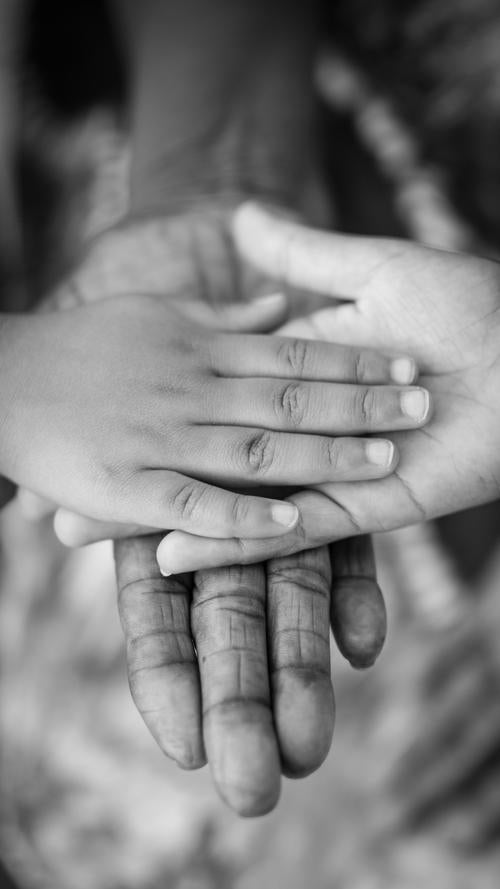 Adult hands with children's hands on top