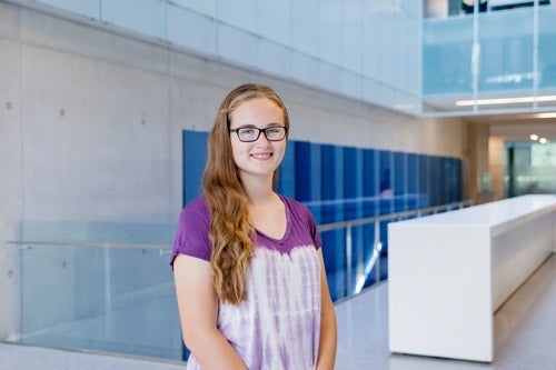Alex Rynard standing in front of QNC staircase