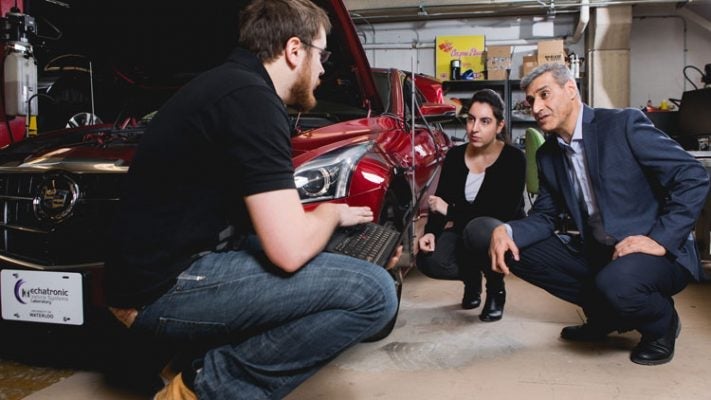 Amir Khajepour working with students in his Waterloo Engineering lab