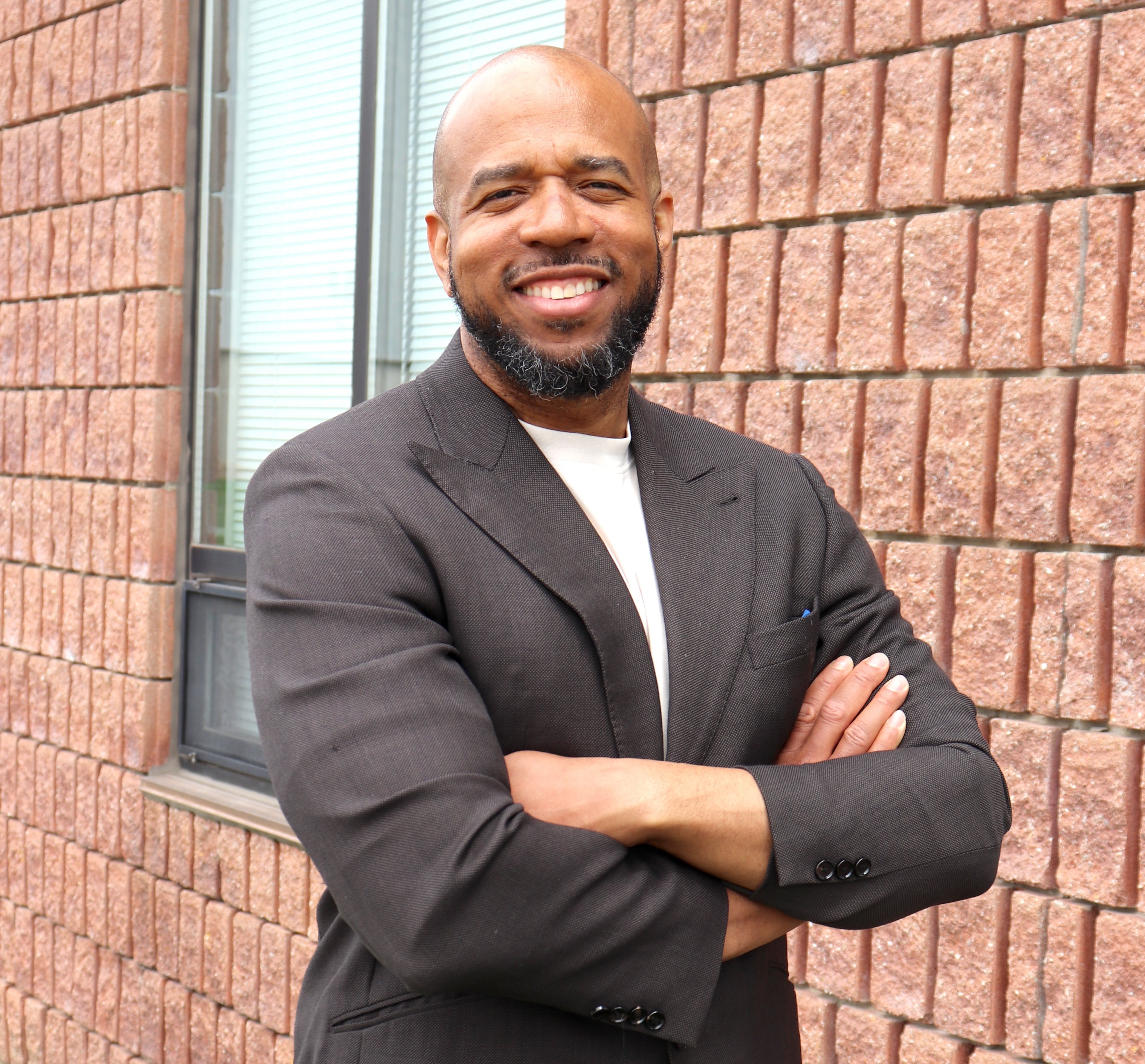 Dr. André Stanberry smiling with arms folded