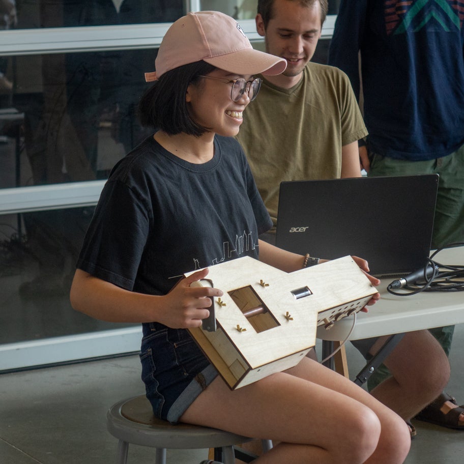 A young engineer demonstrates her hurdy-gurdy