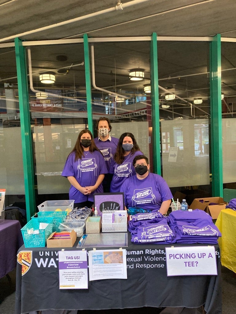A group of people standing behind a table at an information fair