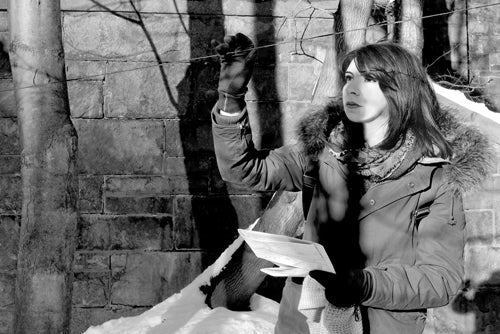 Piper Bernbaum outdoors in winter coat holding papers