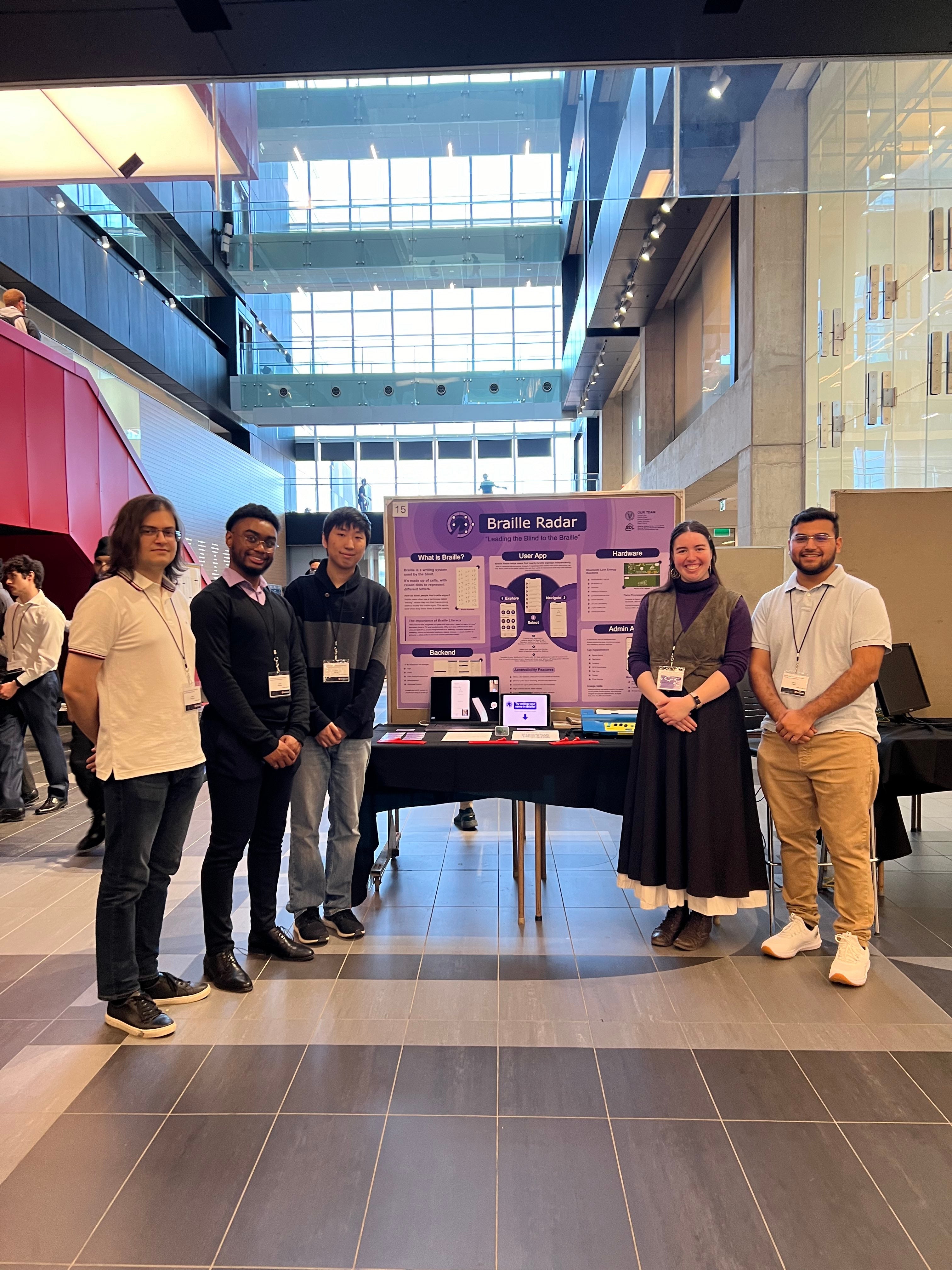 Braille Radar Capstone group standing in front of presentation materials