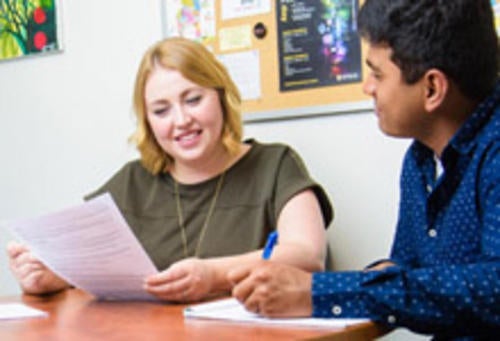 Career advisor helps a visitor with a resume