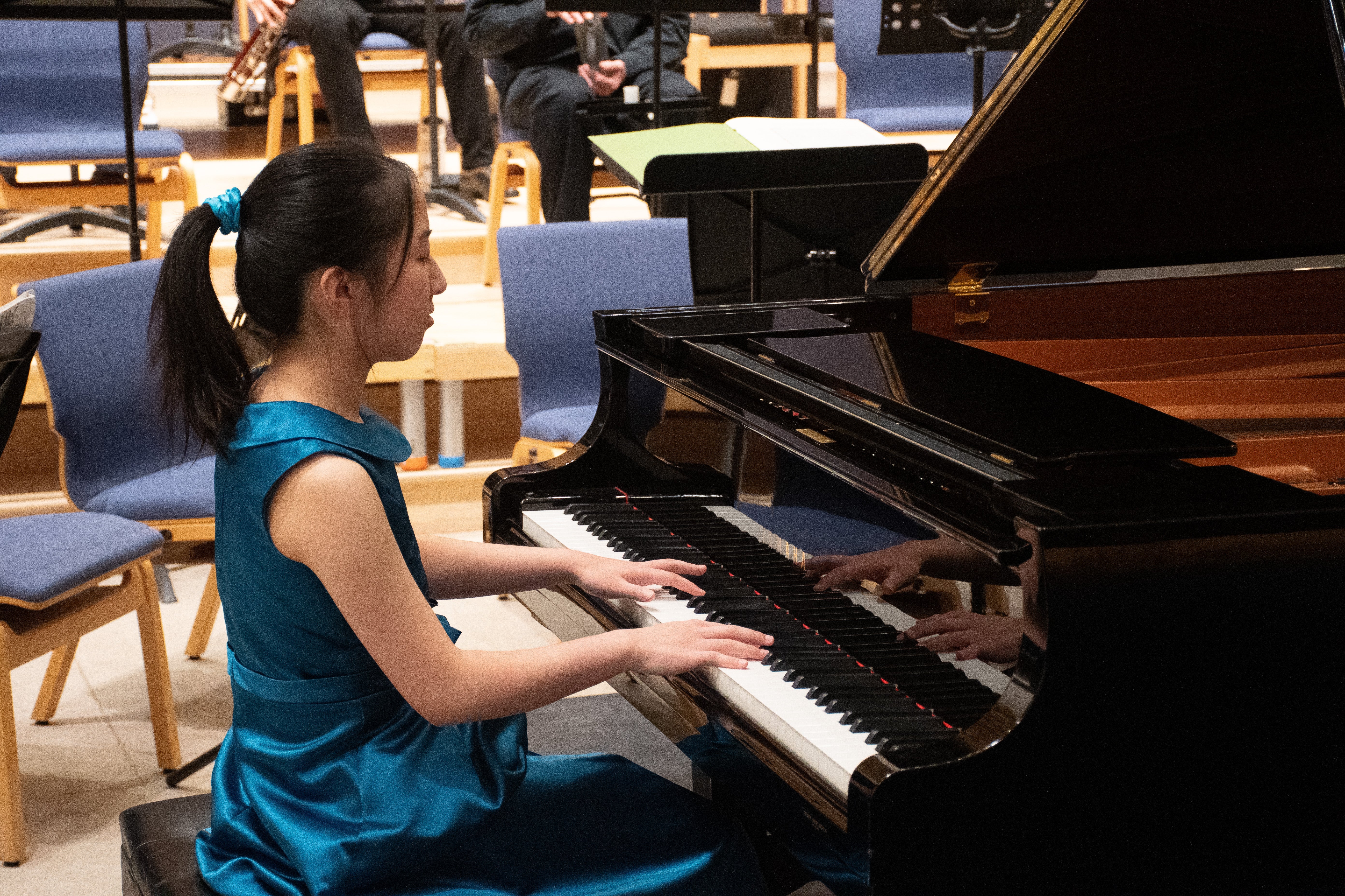 Catherine sits at grand piano