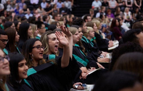 Waterloo graduates cheering while seated for convocation