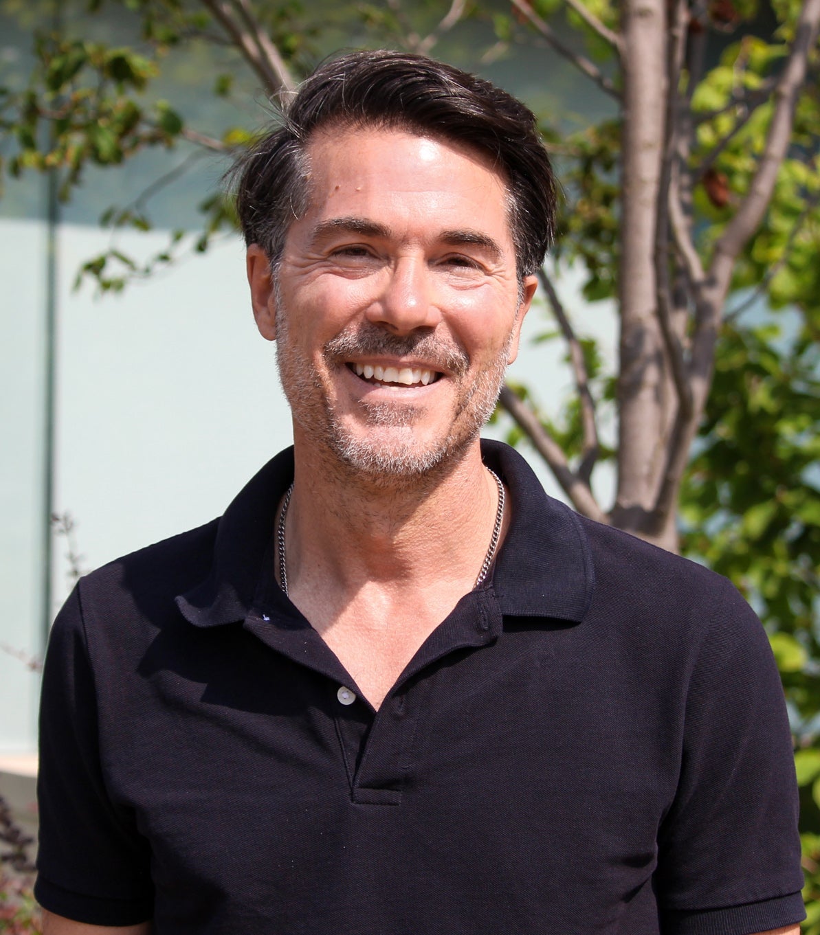 Brian Orend stands outside smiling at the camera