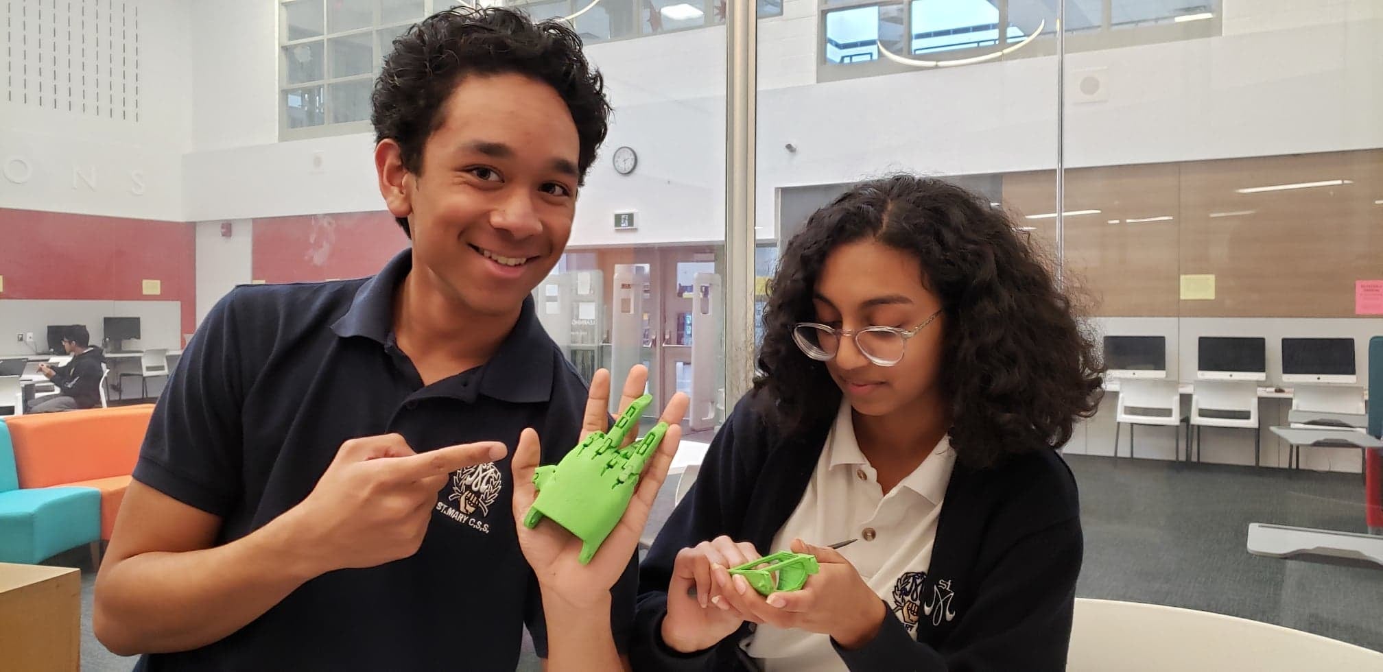 Alex Loo,left,  and Charlene Rocha work on an e-NABLE project