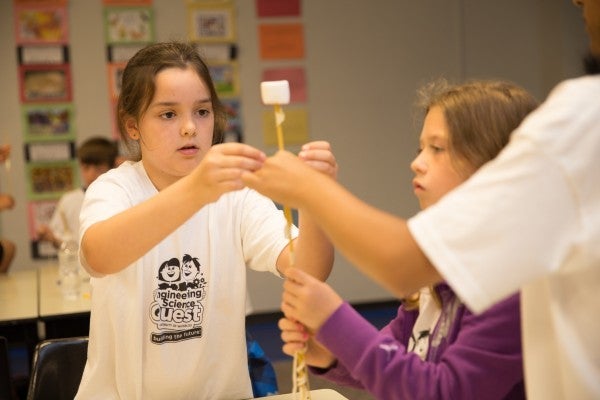 Campers building tall structure to support mashmallow