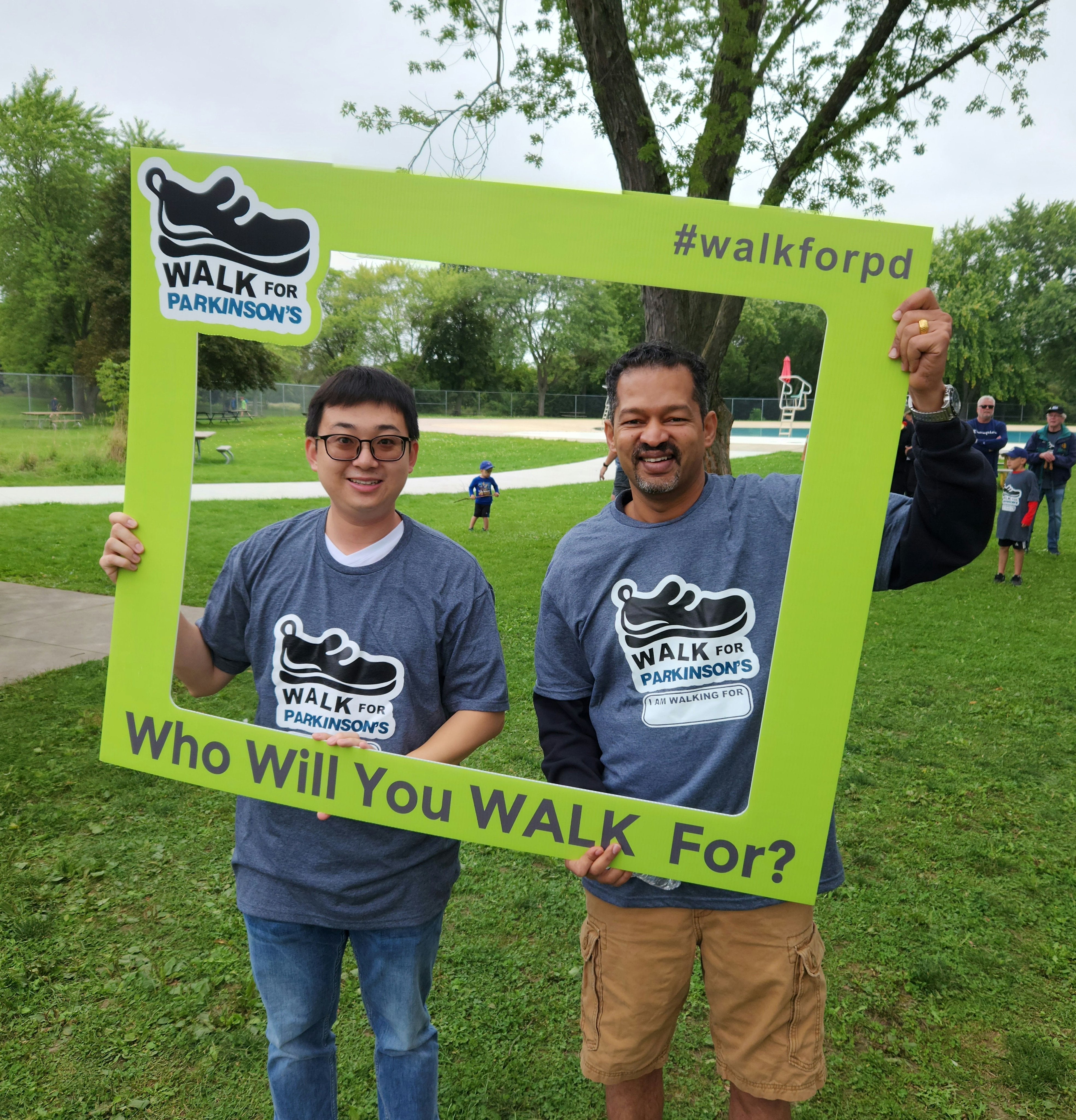 Zhao and Dr. Nekkar Rao at the Walk for Parkinson’s event. They are standing in the middle of a green frame.