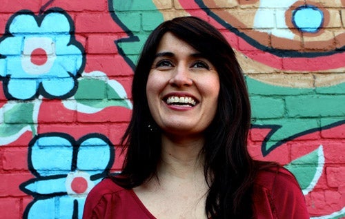 Farrah Khan standing against a colourful wall