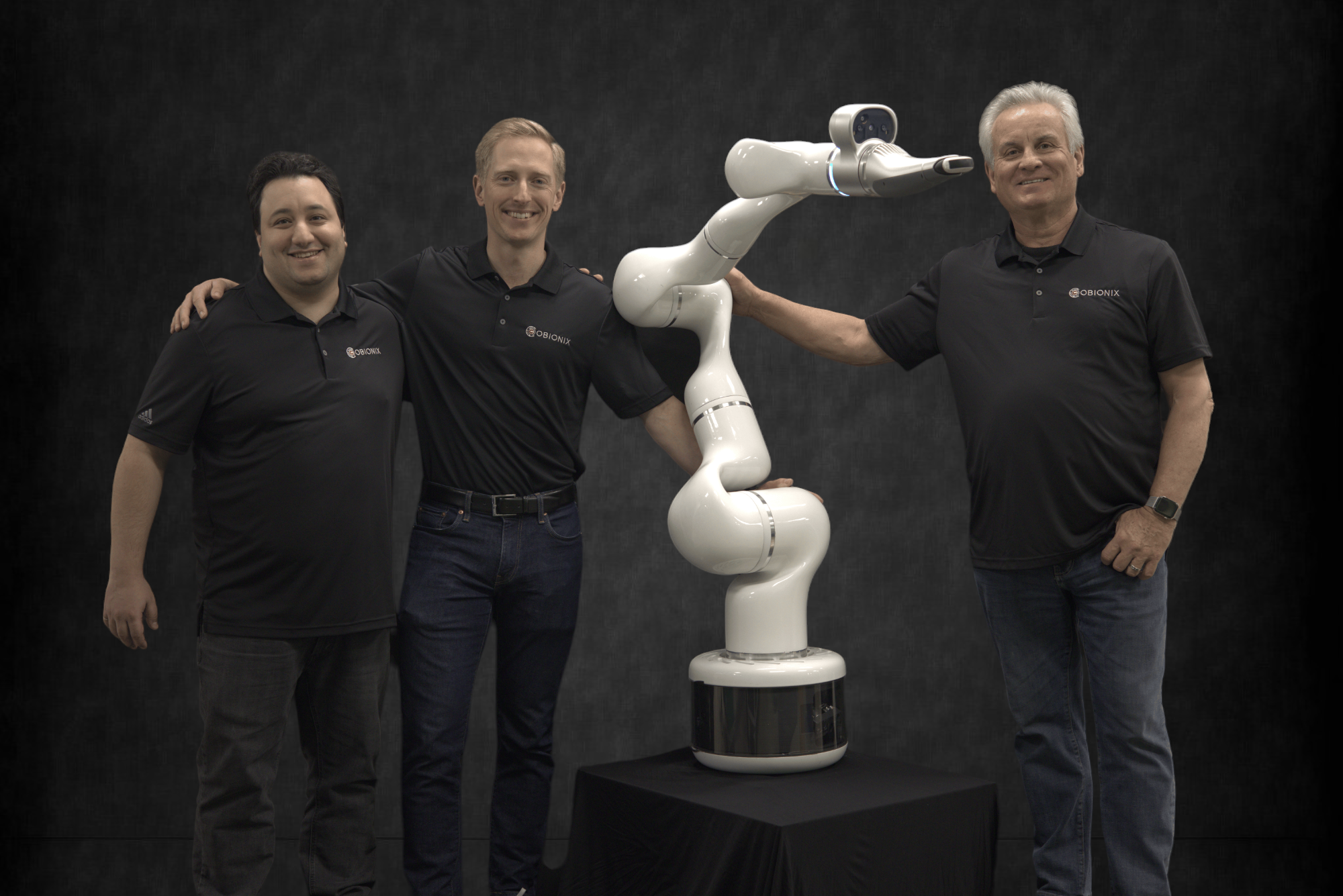 Founders of Cubionix pose with robotic arm