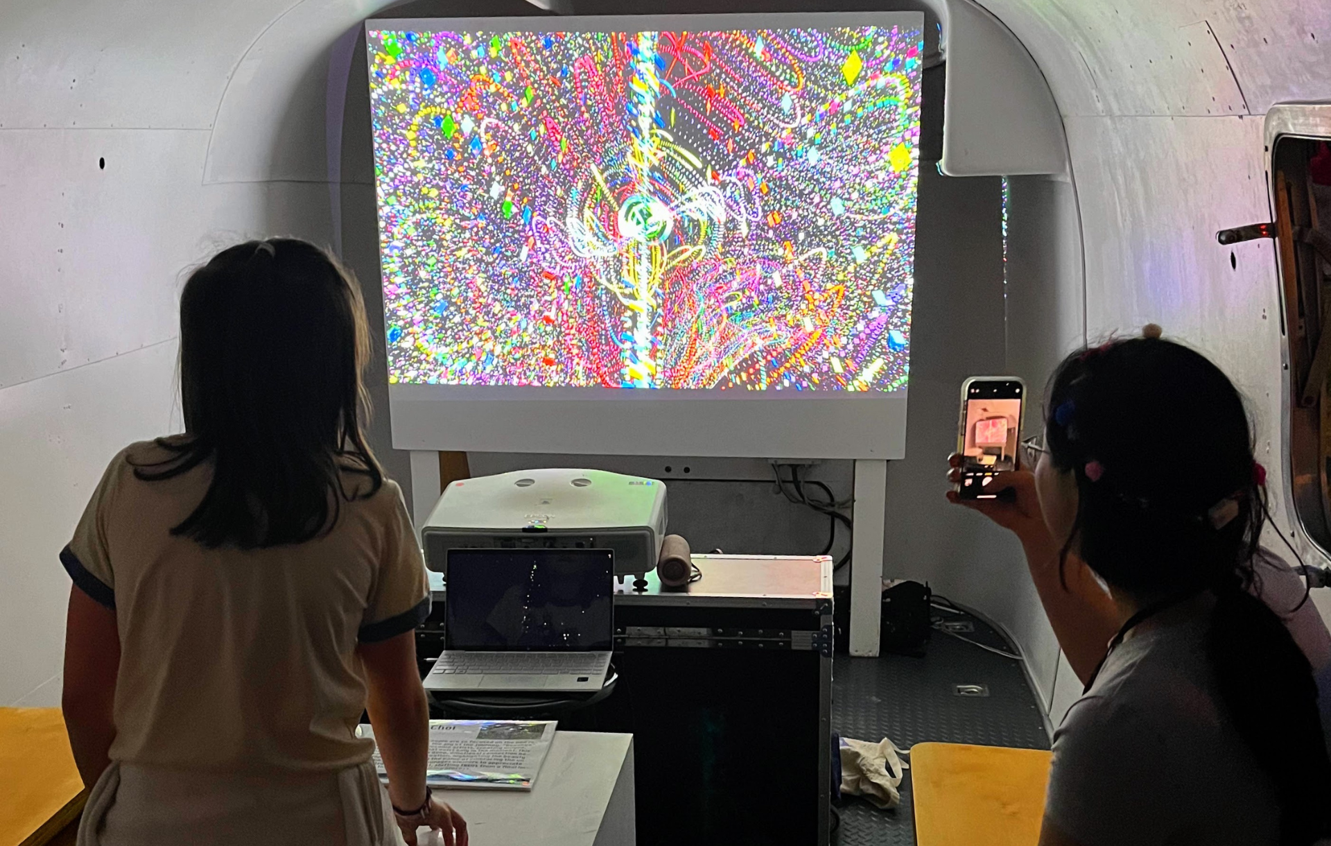 Students in an art bus looking at a abstract designs on a projection screen