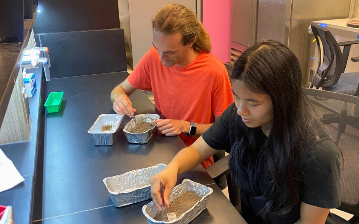Hayden Epp and Mia Hepburn analyzing soil samples in a lab at the University of Waterloo.