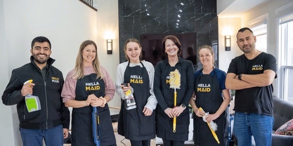 Six Hellamaid staff pose as a group with cleaning tools