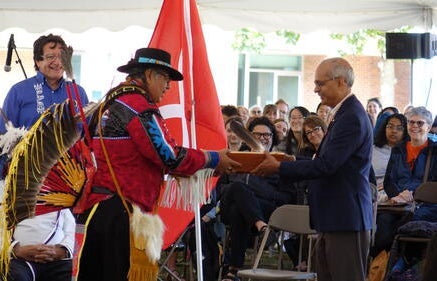 Henry presenting Goel with a gift