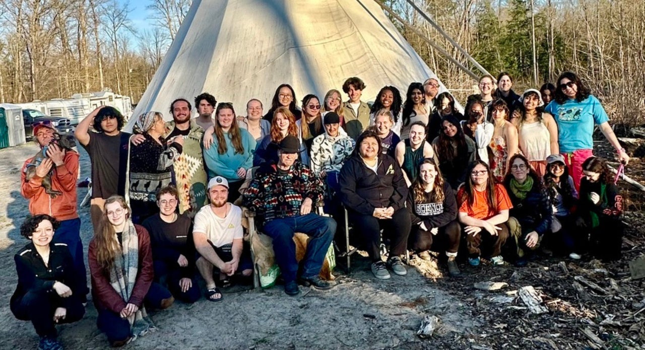 Anishinaabe Elders Mark and Wendy Philips with the Science students in front of a tipi