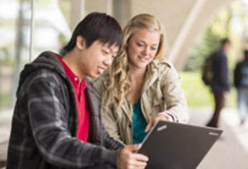 Man and woman look at laptop screen outside Dana Porter Library
