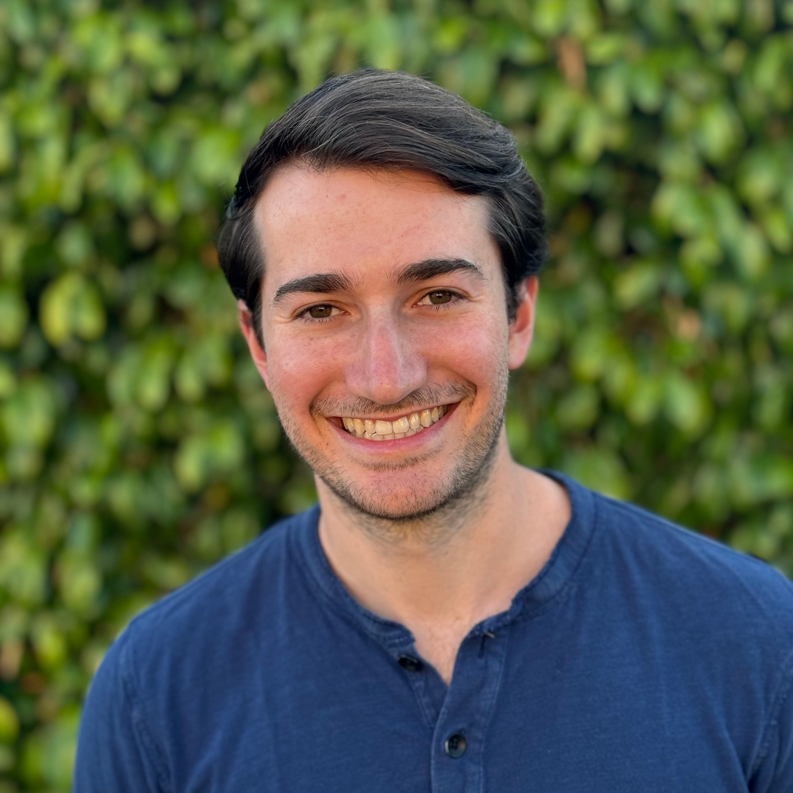 Jeremy Chizewer wears navy blue t-shirt and smiles at the camera