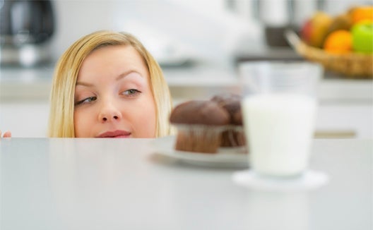 Woman eyeing up a cupcake
