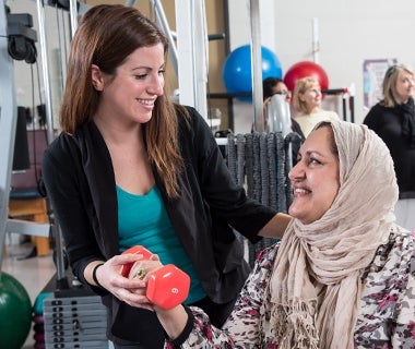 Erin Rellinger-Smith assists a recovering breast cancer patient with workout