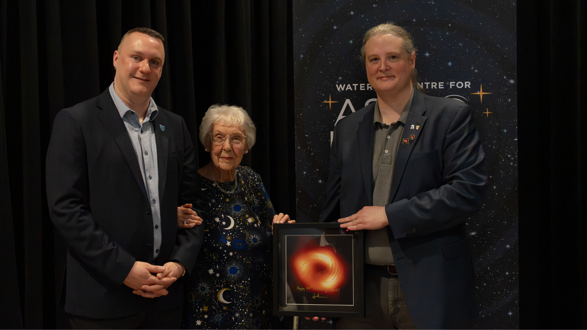 Graham Murphy and Avery Broderick presenting an image of the black hole to Violet Sykes