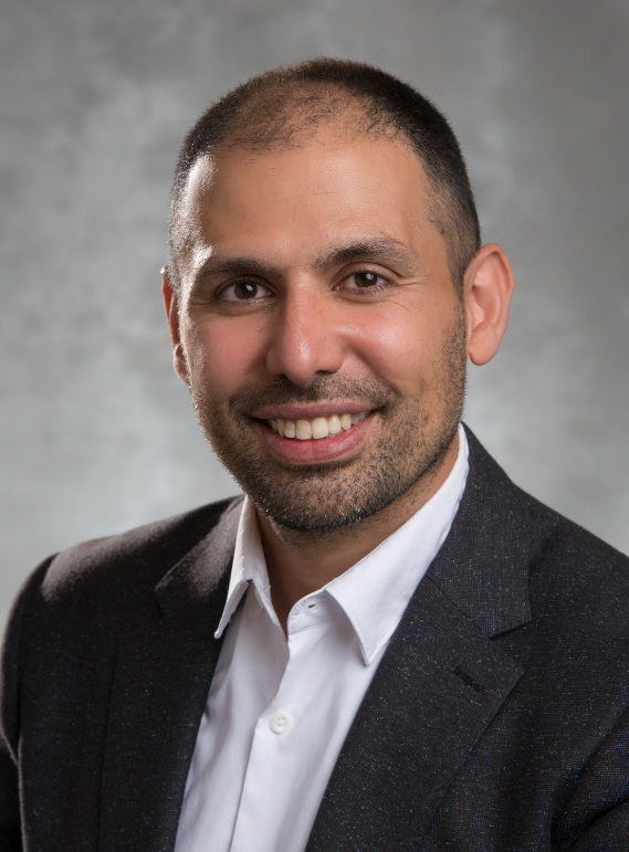 Mehrdad Pirnia wearing a black blazer and white collared shirt.