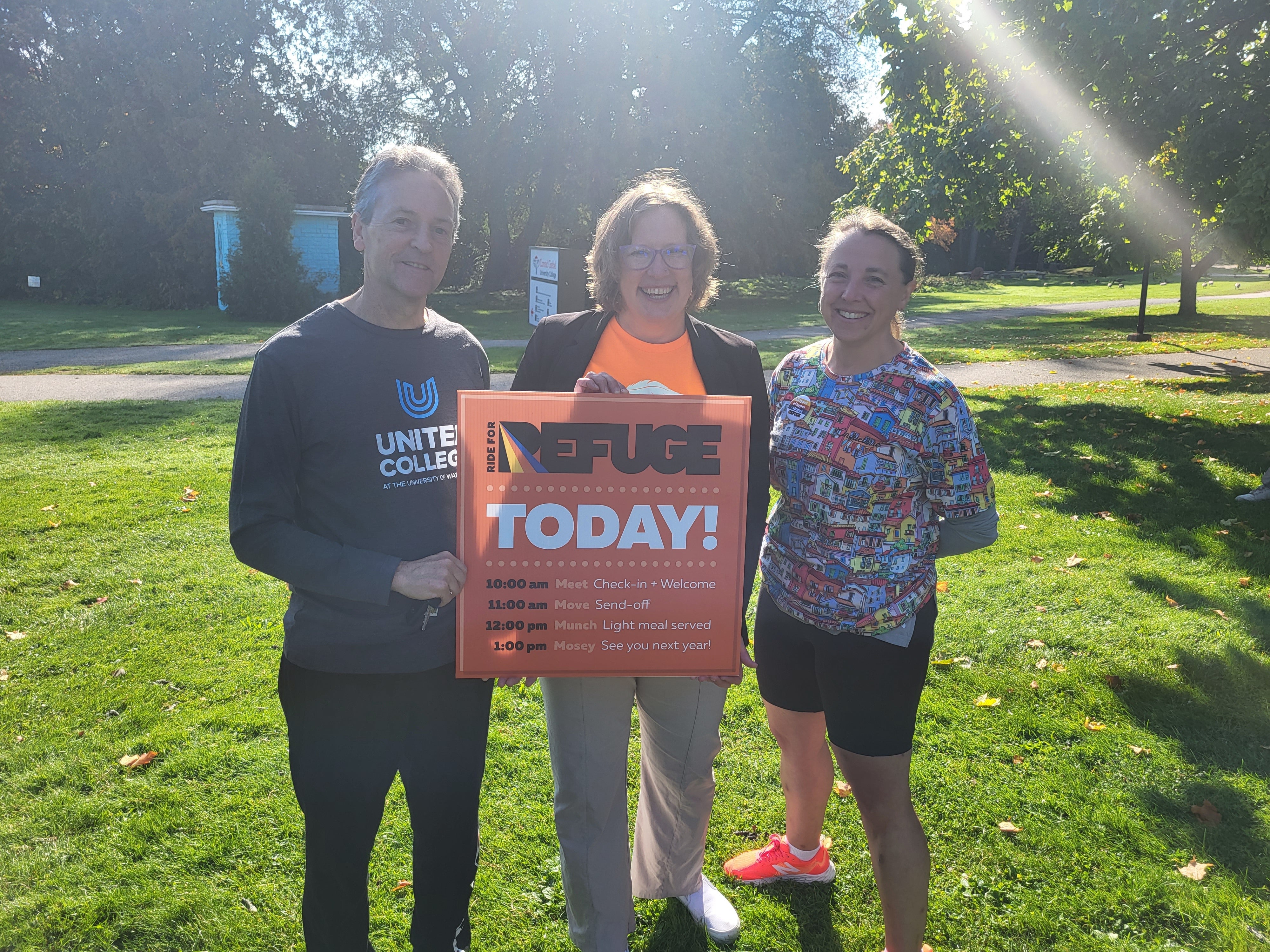 Community volunteers hold "Ride for Refuge" sign
