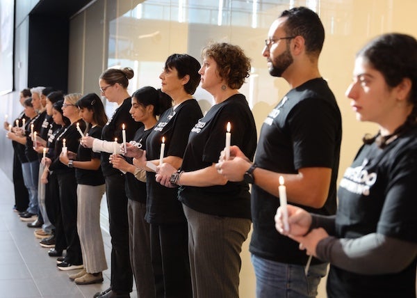 People in a row holding candles