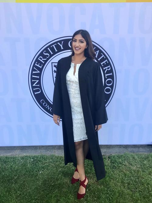 Navdeep standing in front of UWaterloo's emblem