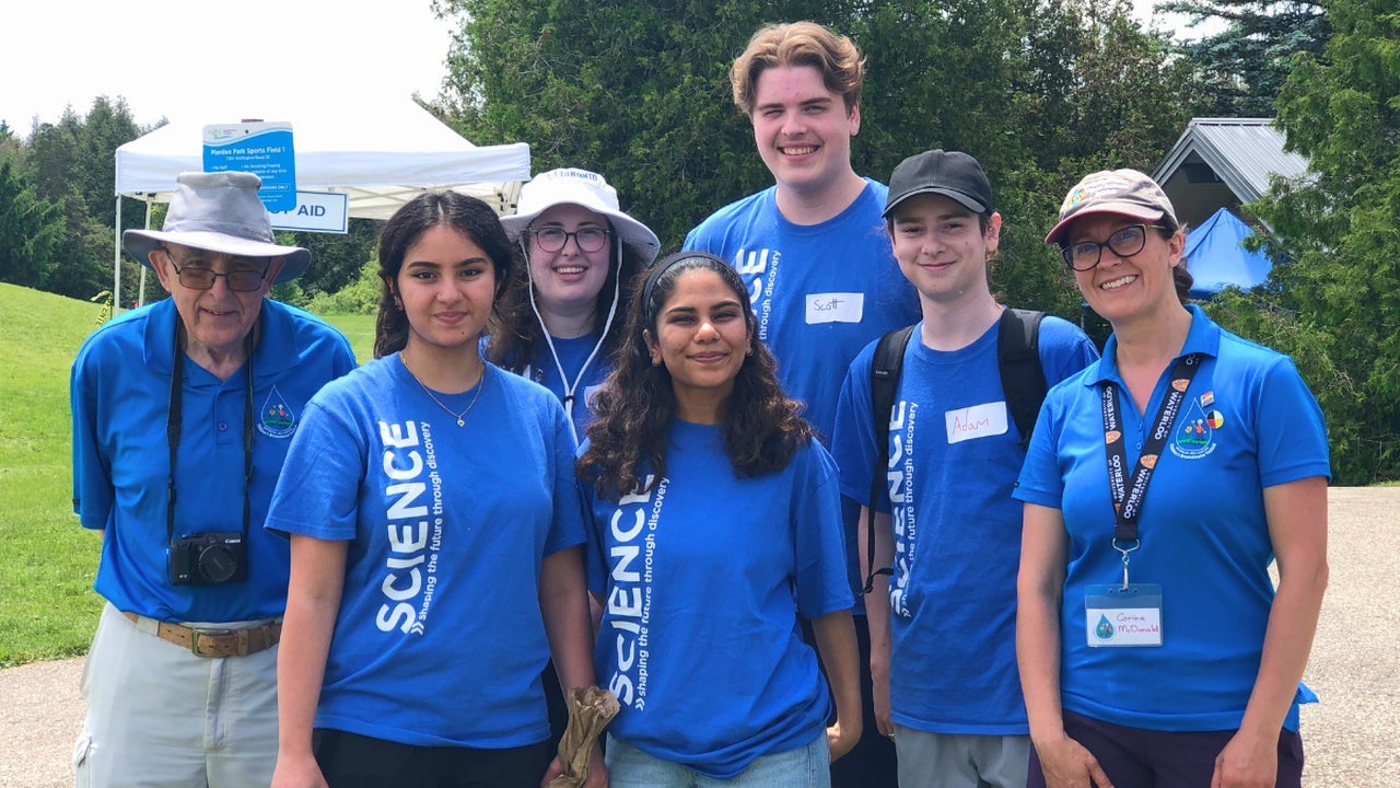 Seven people wearing Science blue t-shirts at an outdoor event for Science outreach.
