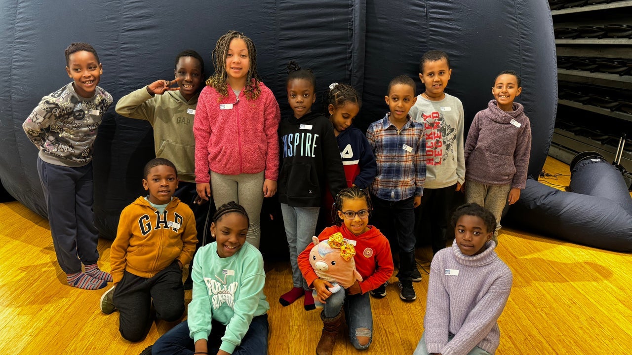 Elementary school kids smiling in front of the Astro-Bubble - an inflatable planetarium.