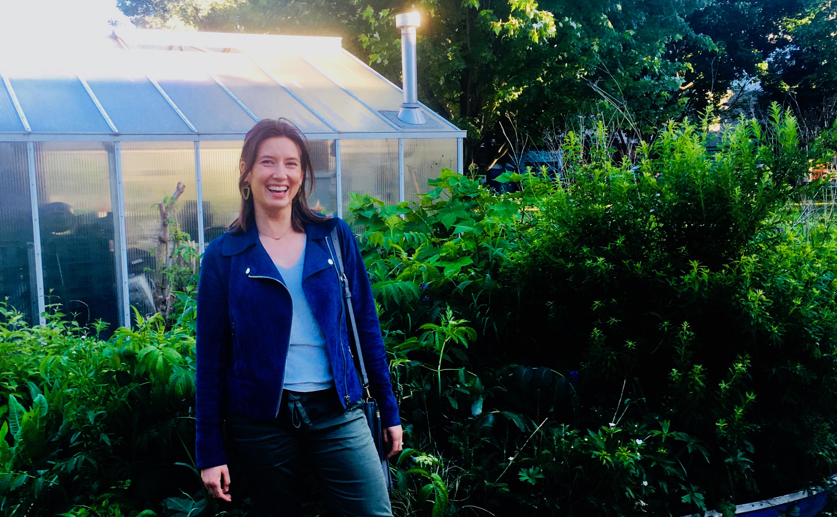 Phoebe Stephens in front of greenhouse
