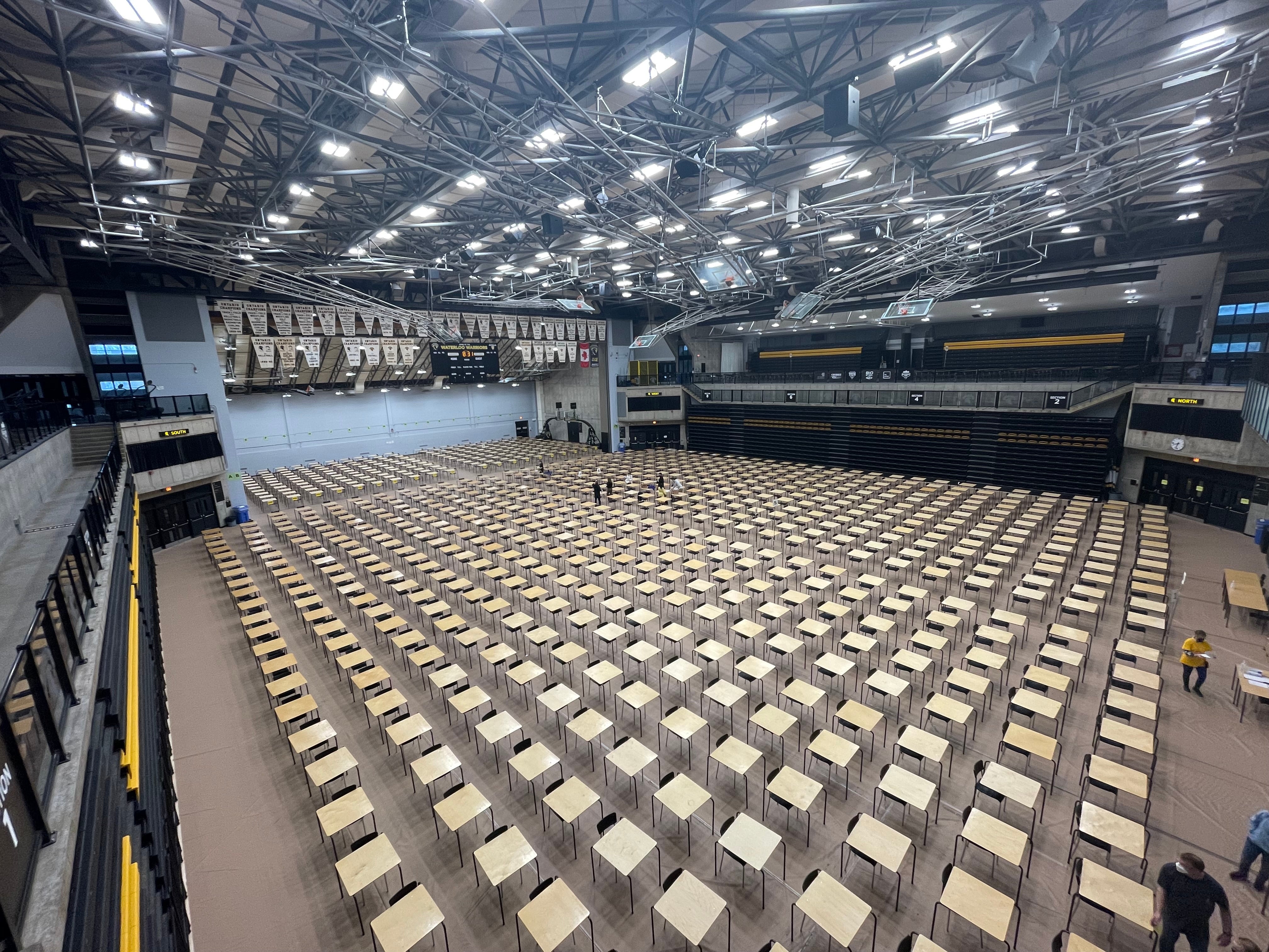 A high angle view of the desks and chairs set up in the Physical Activities Complex for exams.