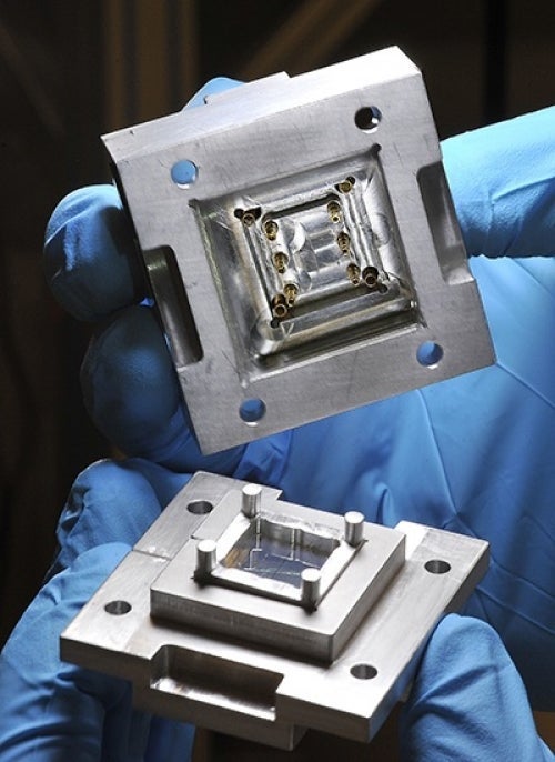 gloved hands holding two pieces of the quantum socket