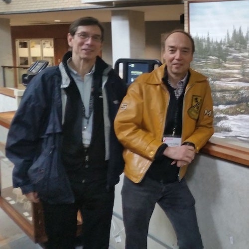 Two men posing for a photo on campus